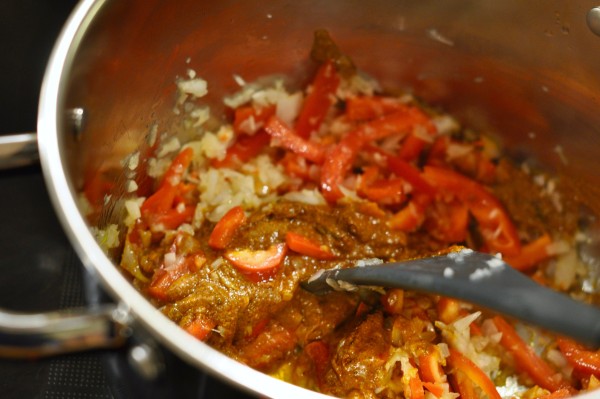 Mixing curry paste with onions and peppers